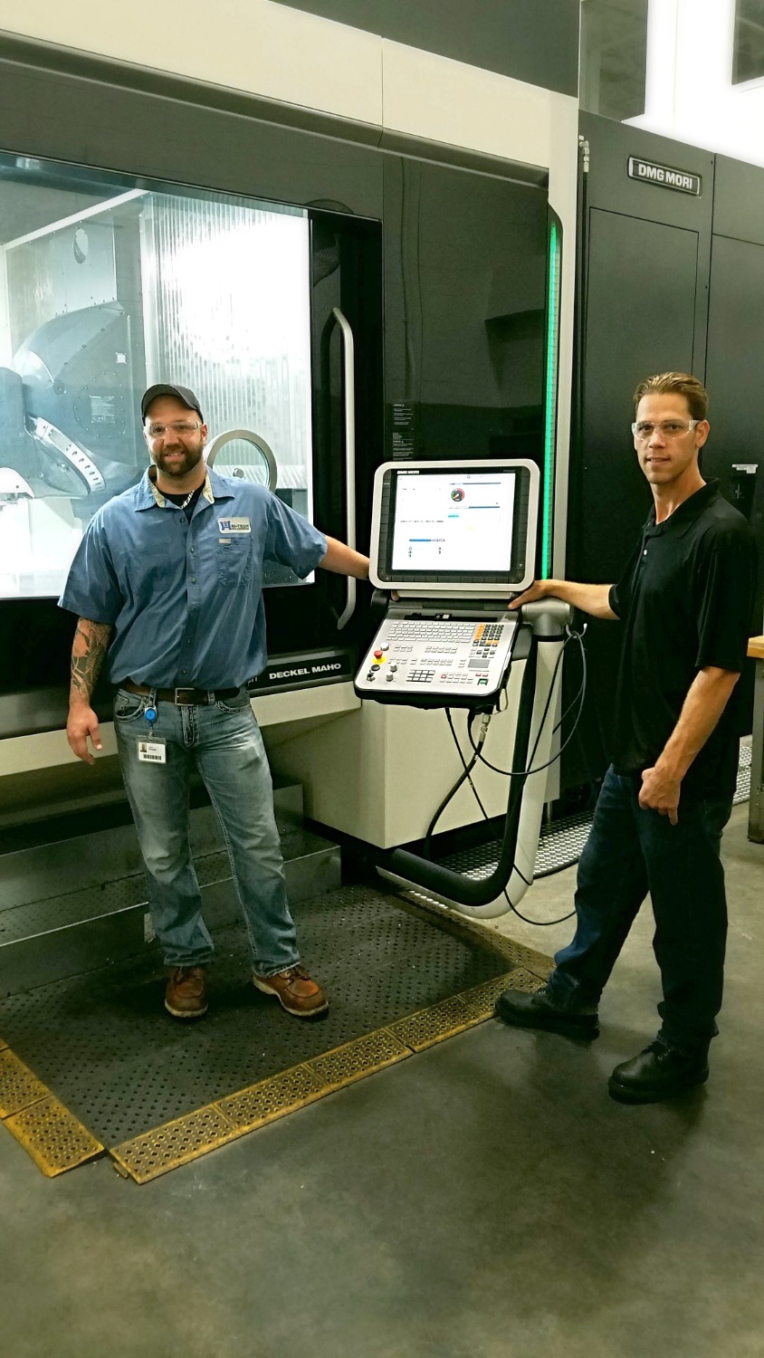 Hi-Tech Mold team members working beside advanced machining equipment
